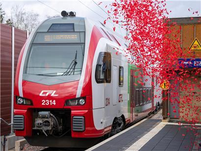 CFL-Zug fährt bei Eröffnung der Trierer Weststrecke am 26. Februar, umgeben von buntem Konfetti.