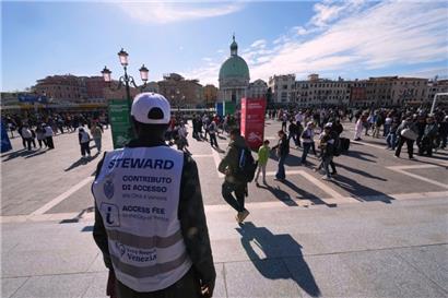 Kontrolleure überprüfen die QR-Codes von Touristen vor dem Hauptbahnhof in Venedig
