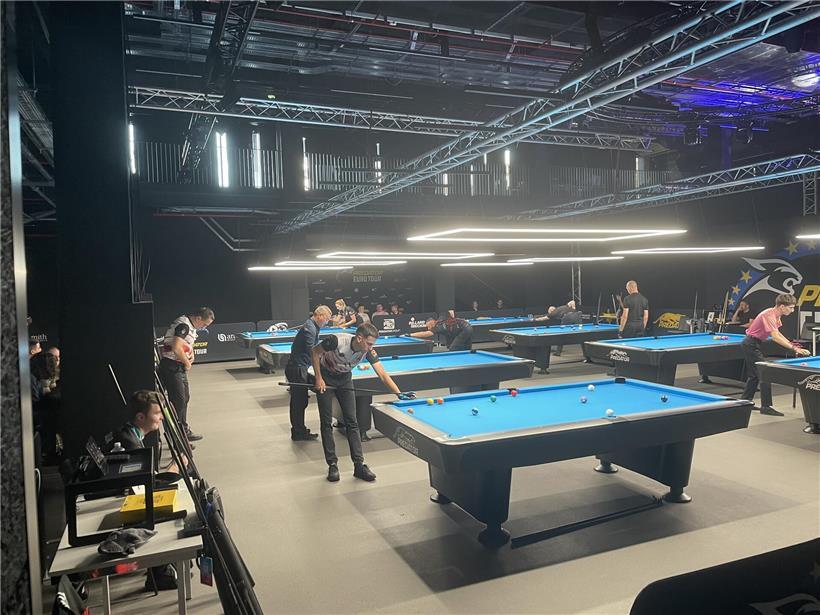 Mann konzentriert beim präzisen Stoß im Poolbillardspiel auf grünem Tisch