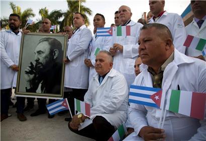 Kubanische Ärzte und Fachleute aus dem medizinischen Bereich lassen sich mit einem Foto von Fidel Castro, sowie kubanischen und italienischen Landesflaggen vor ihrer Reise nach Italien fotografieren. 

