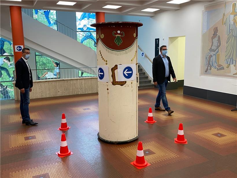 LHCE-Direktor Jean Theis und Vizedirektor Denis Reitz laufen durch den Kreisverkehr im Gymnasium
