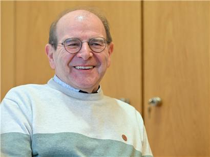 Guy Brecht lacht humorvoll über sich selbst und politische Entscheidungen des Gemeinde- und Schöffenrats.