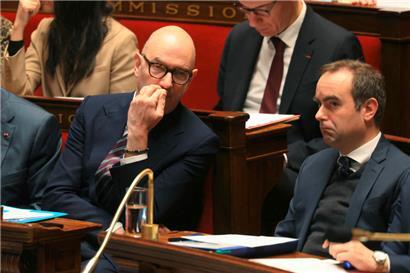 Le ministre des finances, Roland Lescure (g.), en discussion avec le premier ministre Sébastien Lecornu pendant le débat à l‘Assemblée nationale
