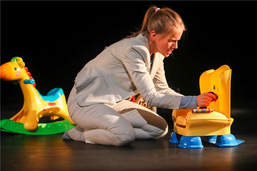Le personnage sans nom, incarné par Jeanne Werner, au milieu des jouets en plastique de ses deux enfants
