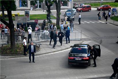Leibwächter bringen den slowakischen Ministerpräsidenten Robert Fico in einem Auto vom Ort des Geschehens in Sicherheit. Fico war nach einer Kabinettssitzung in der Stadt Handlova angeschossen und verletzt worden. 
