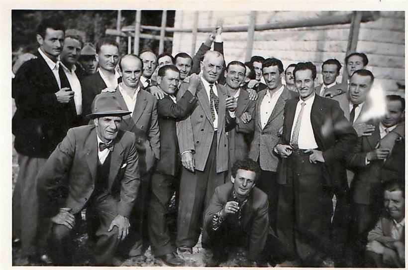 L’entrepreneur luxembourgeois Bauler entouré de ses ouvriers italiens lors d’une „Straussfeier“ dans les années 1950: à sa droite, souriant, Domenico Cancellieri, immigré en 1950 comme ouvrier saisonnier dans le bâtiment, originaire d’Urbania (province de Pesaro et d’Urbino, région des Marches)
