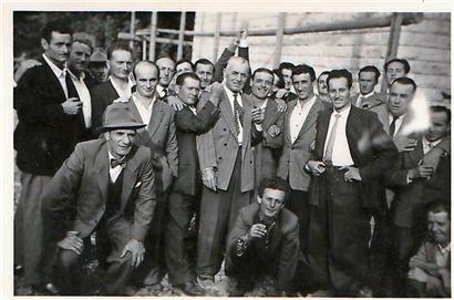 L’entrepreneur luxembourgeois Bauler entouré de ses ouvriers italiens lors d’une „Straussfeier“ dans les années 1950: à sa droite, souriant, Domenico Cancellieri, immigré en 1950 comme ouvrier saisonnier dans le bâtiment, originaire d’Urbania (province de Pesaro et d’Urbino, région des Marches)
