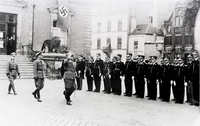 Les occupants nazis passent en revue la compagnie luxembourgeoise sur la place Guillaume. En arrière-plan l’hôtel de ville de la capitale.
