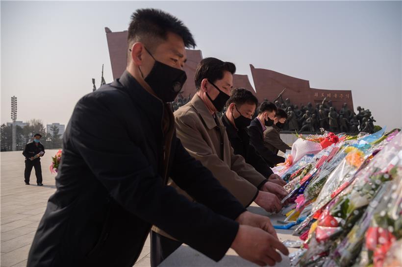 Leute mit Schutzmasken legen Blumen am „Tag der Sonne“ nieder, der in Nordkorea am 15. April begangen wird.

