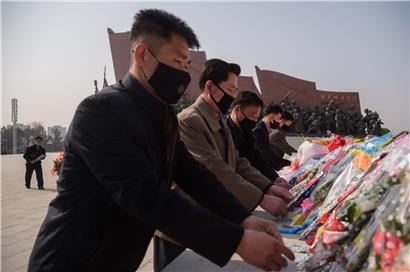 Leute mit Schutzmasken legen Blumen am „Tag der Sonne“ nieder, der in Nordkorea am 15. April begangen wird.
