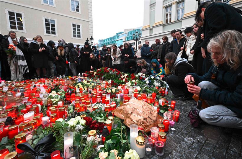 Leute stellen Kerzen auf und legen Blumengebinde vor der Karls-Universität nieder zum Gedenken an die Opfer des Amoklaufs am Donnerstag
