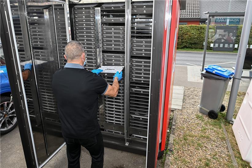 Lieferfahrer Tommaso Quitadamo öffnet hinten am Gerät eine große Klappe, um für Nachschub zu sorgen 

