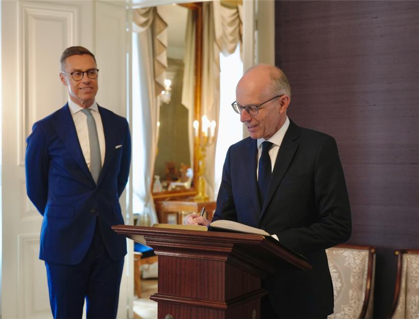 Luc Frieden trägt sich im Präsidentenpalast von Alexander Stubb ins goldene Buch ein
