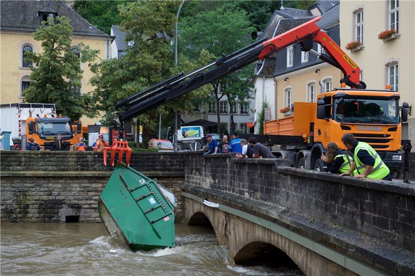 Luxemburg-Stadt: Ein Kran hebt einen mitgerissenen Container aus dem Wasser
