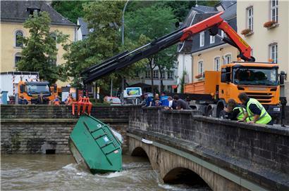 Luxemburg-Stadt: Ein Kran hebt einen mitgerissenen Container aus dem Wasser
