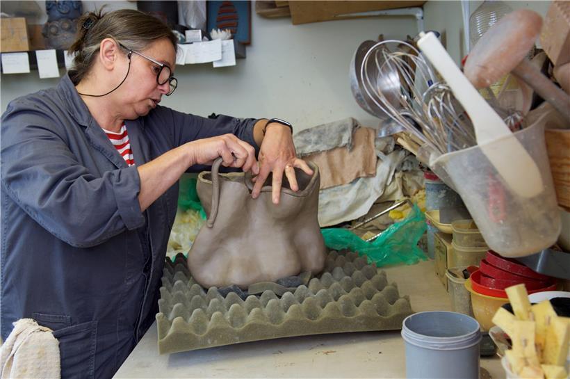 Mady Roef arbeitet an einer Skulptur aus Lehm. Die Form entsteht beim Arbeiten daran. Sie arbeitet ohne Skizzen als Vorlage. 
