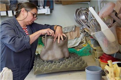Mady Roef arbeitet an einer Skulptur aus Lehm. Die Form entsteht beim Arbeiten daran. Sie arbeitet ohne Skizzen als Vorlage. 
