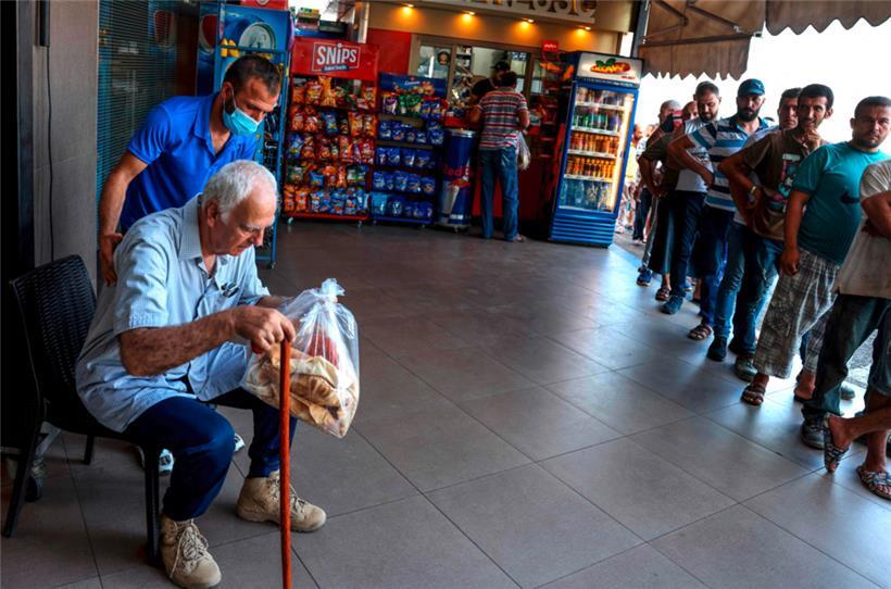 Männer stehen vor einer Bäckerei in Beirut für Brot an
