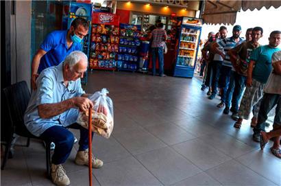 Männer stehen vor einer Bäckerei in Beirut für Brot an
