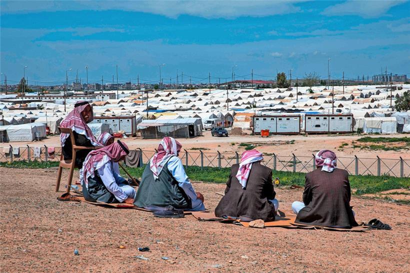 Männer vom Volk der Jesiden sitzen im Irak vor einem Flüchtlingslager. Dschihadisten des sogenannten Islamischen Staates hatten Frauen der Jesiden als Sex-Sklavinnen gefangengehalten.
