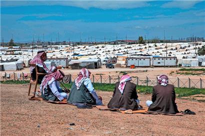 Männer vom Volk der Jesiden sitzen im Irak vor einem Flüchtlingslager. Dschihadisten des sogenannten Islamischen Staates hatten Frauen der Jesiden als Sex-Sklavinnen gefangengehalten.
