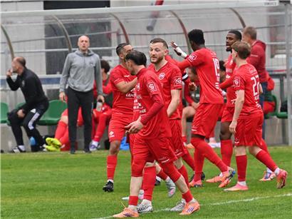 Fußballspiel Mamer gegen Wiltz auf dem Spielfeld mit Spielern in Aktion bei sonnigem Wetter