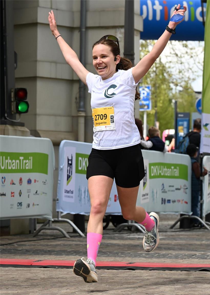 Marguerite Dupuis beim Zieleinlauf als Siegerin eines 18-Kilometer-Rennens in Sportkleidung