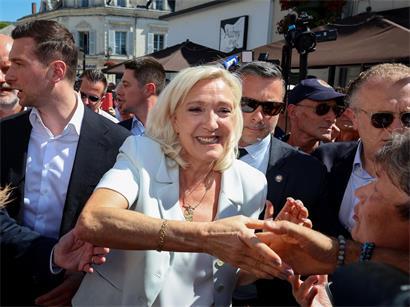 Marine Le Pen lächelt selbstbewusst bei einer Wahlkampfveranstaltung, Umfragen zeigen Führung bei Präsidentschaftswahl