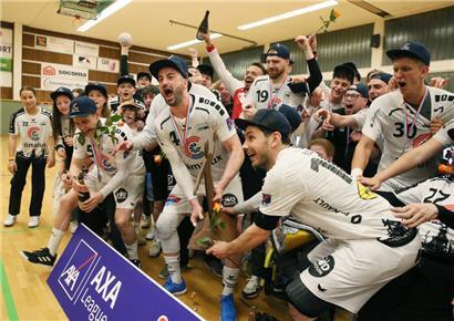 Martin Muller (Nummer 4) und Sacha Pulli, die beide ihre Handballkarrieren beenden, nehmen die Meistertrophäe entgegen
