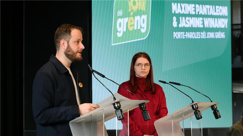 Maxime Pantaleoni und Jasmine Winandy, neue Sprecher von déi jonk gréng, stehen zusammen vor neutralem Hintergrund