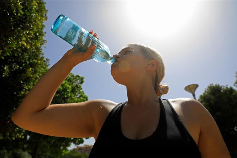 Mayra aus Mallorca trinkt Wasser während einer Hitzewelle im Sommer
