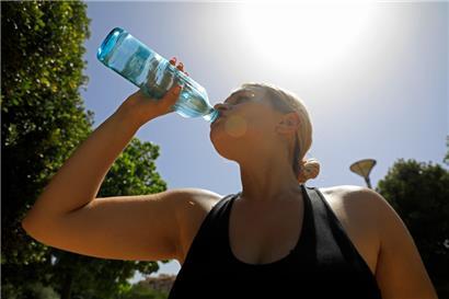 Mayra aus Mallorca trinkt Wasser während einer Hitzewelle im Sommer
