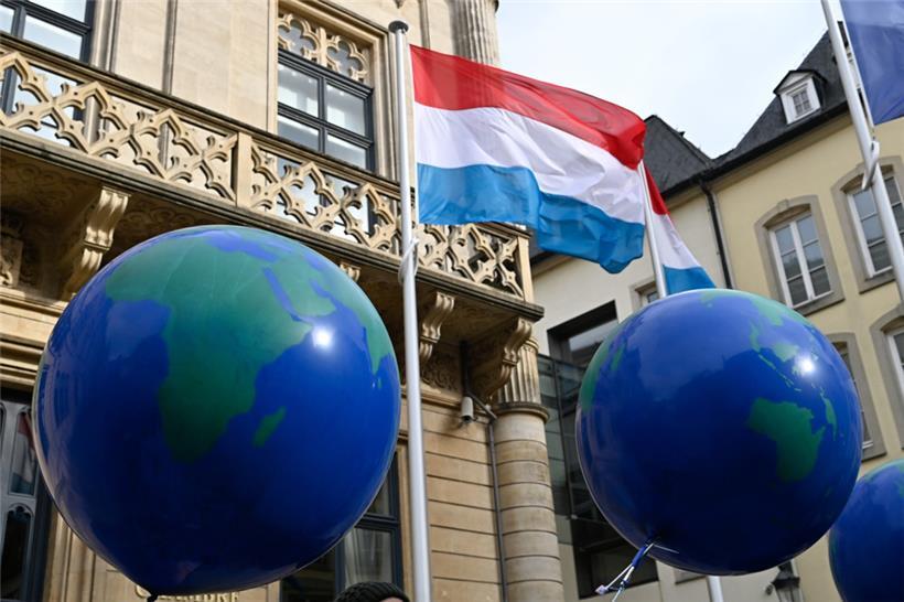 Mehrere Luftballons, die Weltkugeln darstellen sollen, sind bei einer Protestaktion der Umweltorganisation „Mouvement écologique“ zum Overshoot Day vor dem Luxemburger Parlament im Jahr 2022 zu sehen
