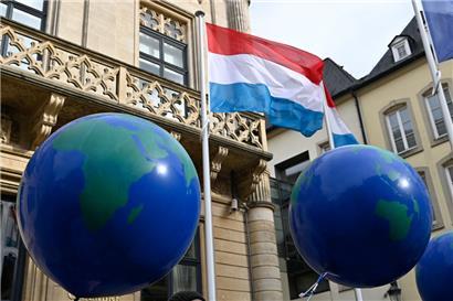 Mehrere Luftballons, die Weltkugeln darstellen sollen, sind bei einer Protestaktion der Umweltorganisation „Mouvement écologique“ zum Overshoot Day vor dem Luxemburger Parlament im Jahr 2022 zu sehen
