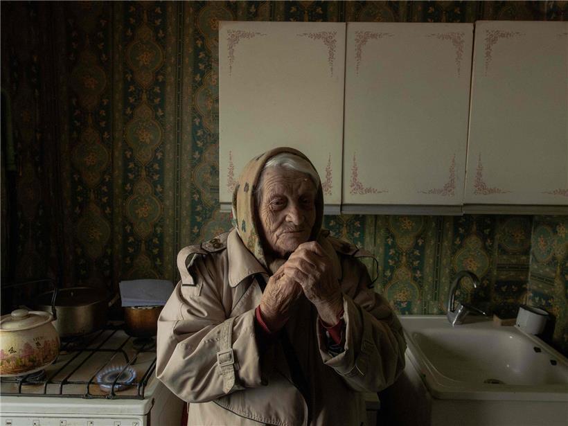 89-jährige Jewgenia Jeromina in ihrer Küche mit tauben Händen und Fingern, Alltag einer älteren Person