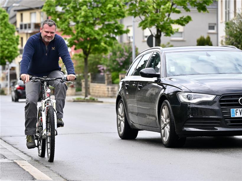Radfahrer und Autos teilen sich eine Straße, veranschaulicht Herausforderungen der Mobilitätswende im Straßenverkehr
