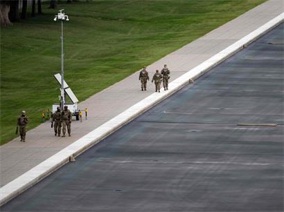 Members of the National Guard walk along the drained Lincoln Memorial Reflecting Pool on the National Mall in Washington, DC on July 30, 2026. The renovation of the pool next to Lincoln Memorial is a pet project of US President Donald Trump’s, but the remodel has been dogged by the growth of algae and peeling paint which the president alleges is the work of vandals. (Photo by Kent Nishimura / AFP)