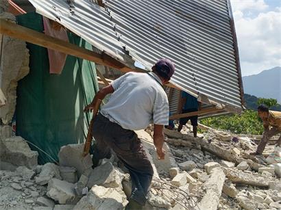 Menschen begutachten die Schäden an einem Haus nach einem Erdbeben in Ost-Manggarai in der Provinz Ost-Nusa Tenggara