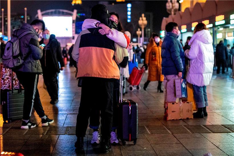 Menschen, die Schutzmasken tragen, kommen im Pekinger Bahnhof an
