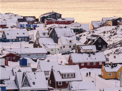 Menschen gehen auf belebter Straße in Nuuk, Hauptstadt von Grönland, bei klarem Wetter