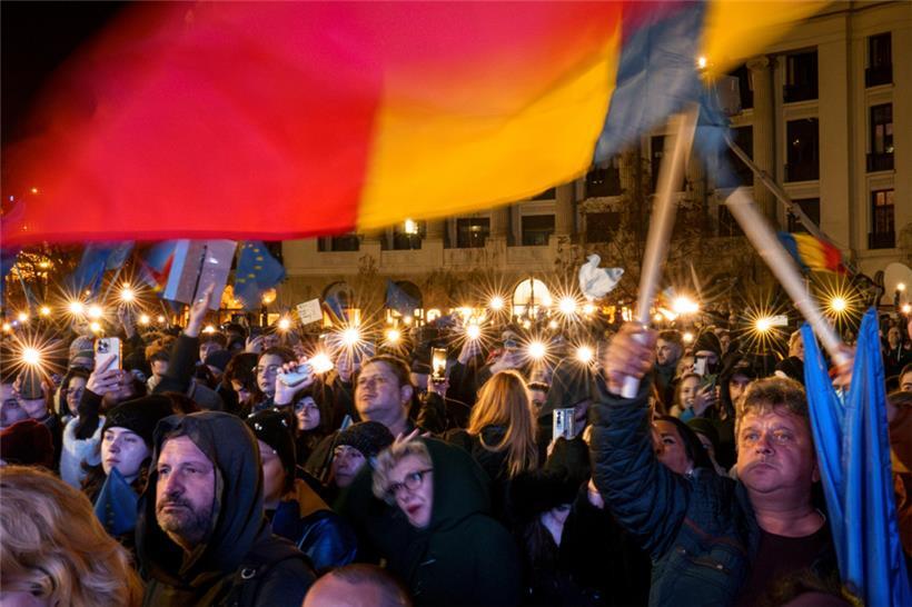 Menschen halten Handys mit Taschenlampen während einer pro-europäischen Kundgebung vor der Stichwahl zur Präsidentschaft in Bukarest
