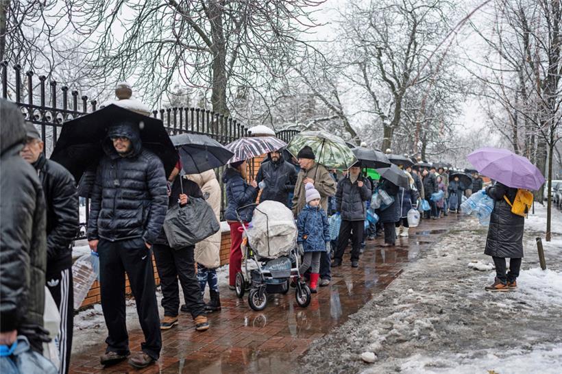 Menschen in Kiew warten in einer Schlange, um in einem Park Wasser zu holen
