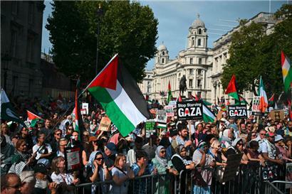 Menschen in London halten Plakate und palästinensische Flaggen während eines nationalen Marsches für Palästina Anfang September hoch
