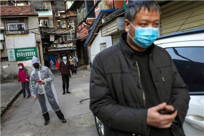 Menschen in Wuhan halten Abstand, während sie für Schweinefleisch anstehen. Theoretisch können die Behörden den Standort von jedem Bürger feststellen, der ein Smartphone bei sich trägt.
