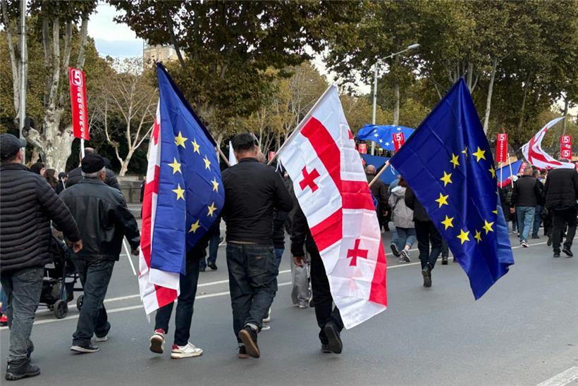 Menschen kommen mit georgischen und EU-Fahnen zu einer Demonstration in der georgischen Hauptstadt. Die Veranstaltung wenige Tage vor der Parlamentswahl in der Südkaukasusrepublik stand unter dem Motto «Georgien wählt die Europäische Union».
