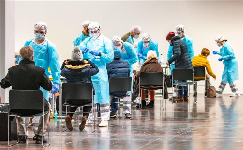 Menschen lassen sich am ersten Tag von Corona-Massentests in Österreich an einer Teststation in der Innsbrucker Messe auf das Coronavirus testen
