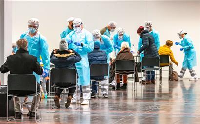 Menschen lassen sich am ersten Tag von Corona-Massentests in Österreich an einer Teststation in der Innsbrucker Messe auf das Coronavirus testen
