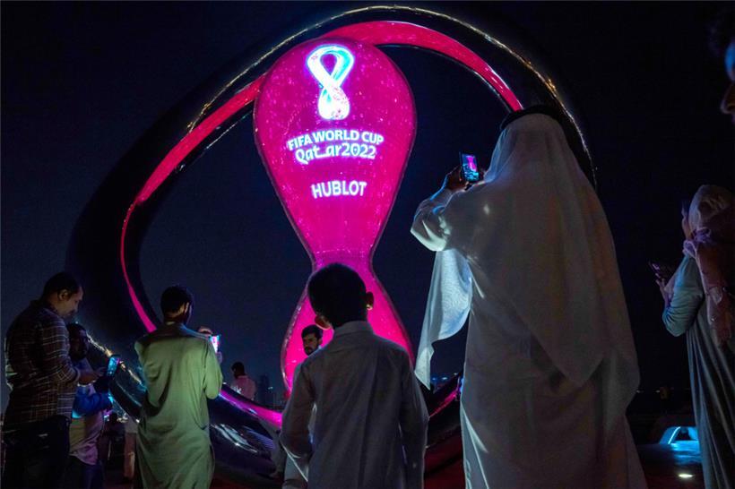 Menschen machen am 14. Oktober Fotos vor der offiziellen Countdown-Uhr der Fußball-WM 2022 auf der Corniche von Doha
