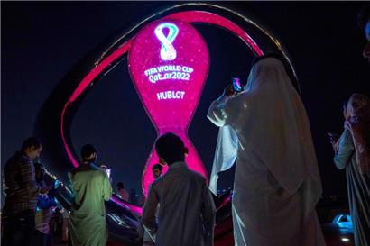 Menschen machen am 14. Oktober Fotos vor der offiziellen Countdown-Uhr der Fußball-WM 2022 auf der Corniche von Doha
