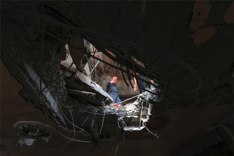 Menschen prüfen die Schäden in einem Gebäude nach einem israelischen Bombenangriff in Khan Yunis im südlichen Gazastreifen am 11. November 2023
